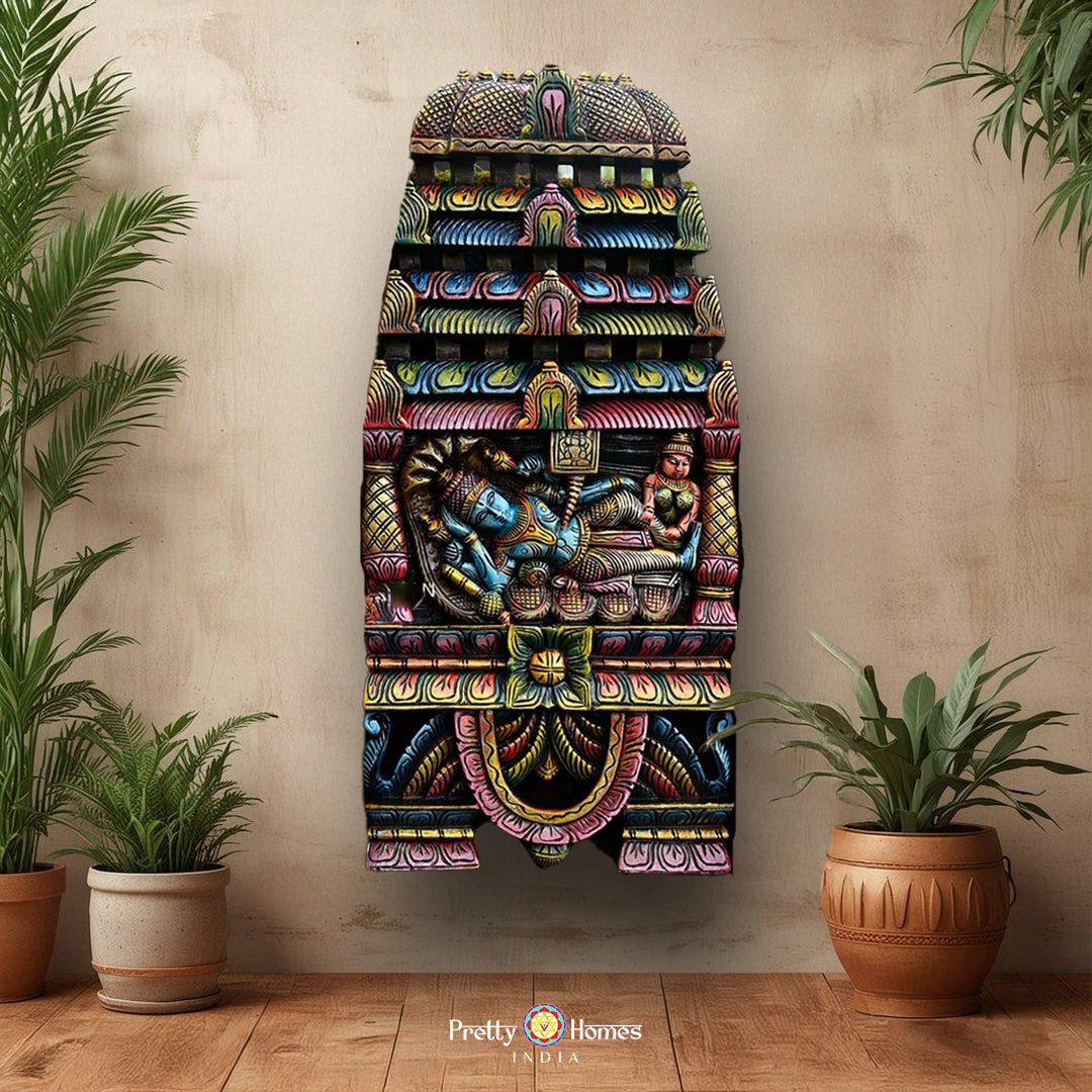 A colorful hand-carved wooden panel depicting Ranganathar (Vishnu reclining on Adishesha) with intricate details and vibrant colors, mounted on a wall.