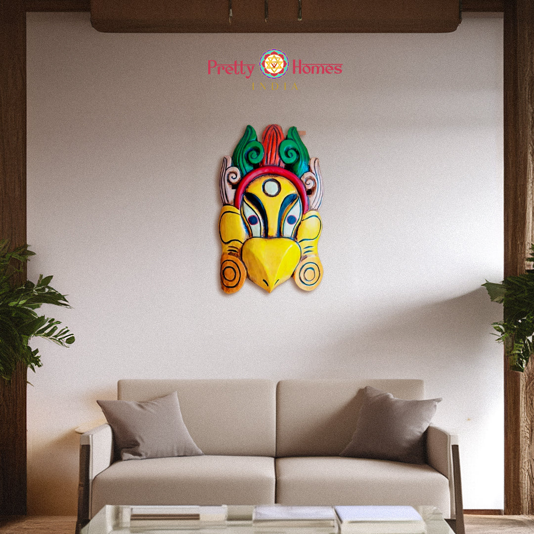 Vibrant hand-painted green and yellow wooden mask with stylized beak ethnic wall decor.