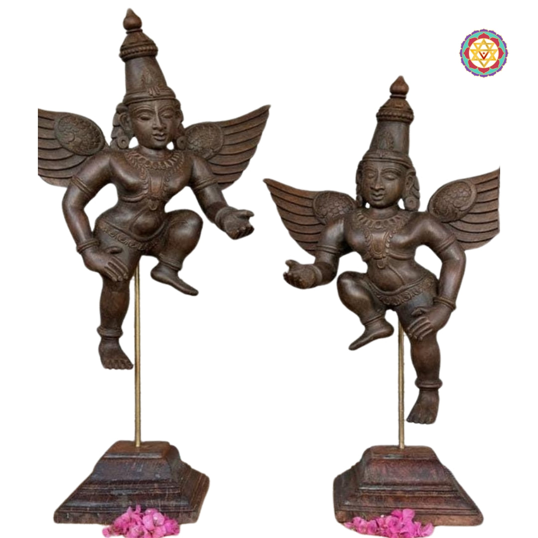 Detailed close-up of carved wooden Gandharva pair showing facial features, wing carving and stepped wooden bases — handcrafted decor
