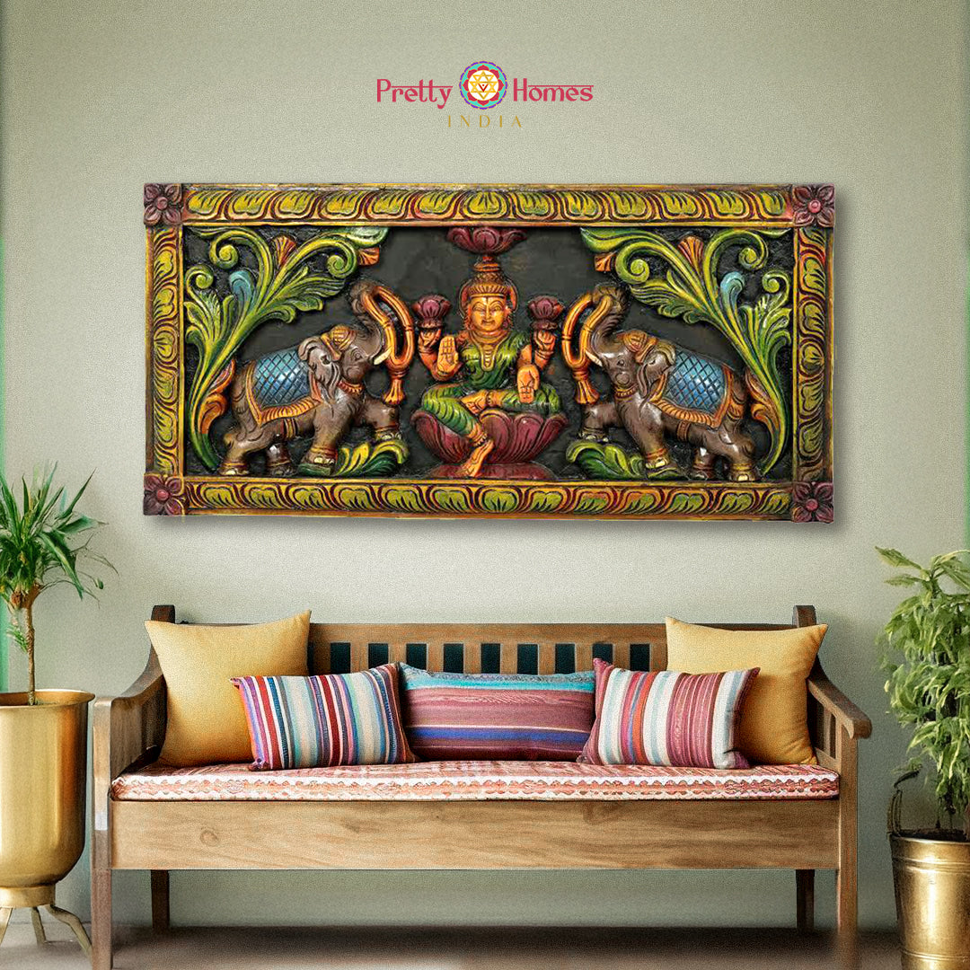 Hand-carved GajaLakshmi wall panel in multicolour finish above sofa