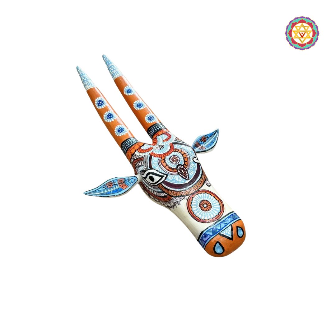 frontal shot of orange and blue cow head showing ornamental motifs and artistic color contrast