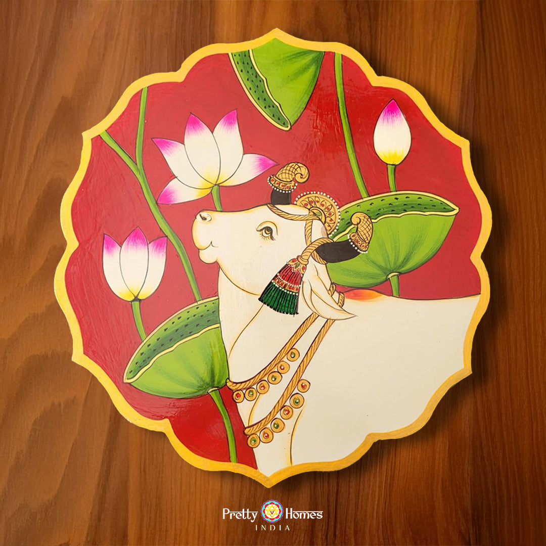 Petal-shaped 12-inch wall plate with hand-painted pichwai cow and lotus pichwai painting on red background. Ideal for pichwai home decor.
