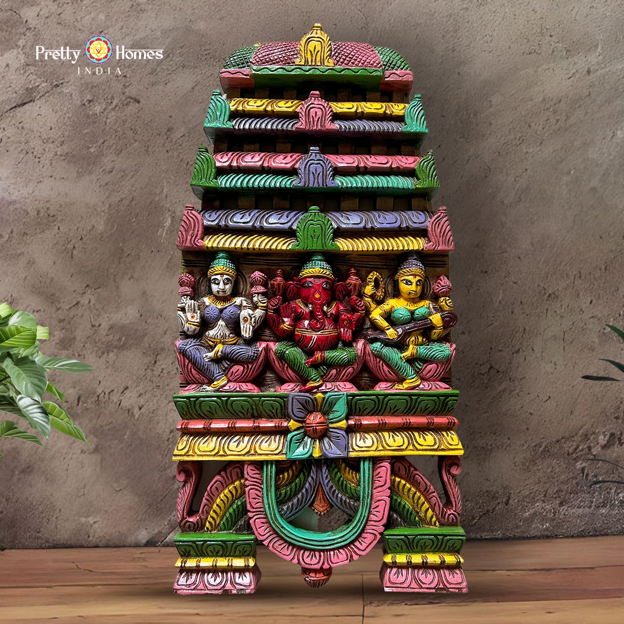 Hand-carved wooden wall panel featuring Ganesha, Laxmi, and Saraswati under Kavadi arch — antique gold finish, devotional decor
