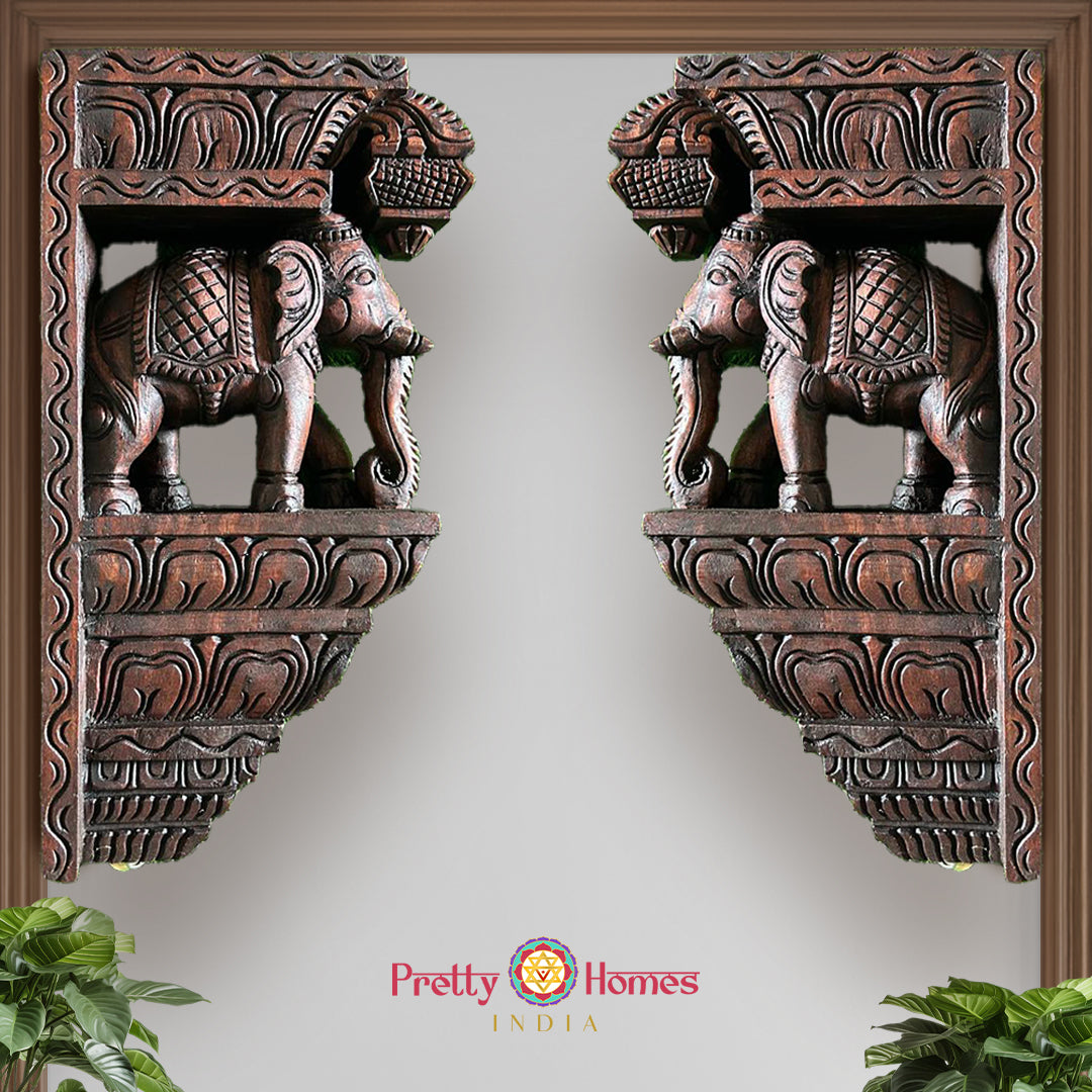 Front view of wooden elephant wall brackets showing carved elephant heads and floral designs