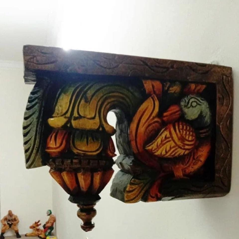 Close-up view of wooden bodhil bracket showing intricate swan carving and handcarved floral borders