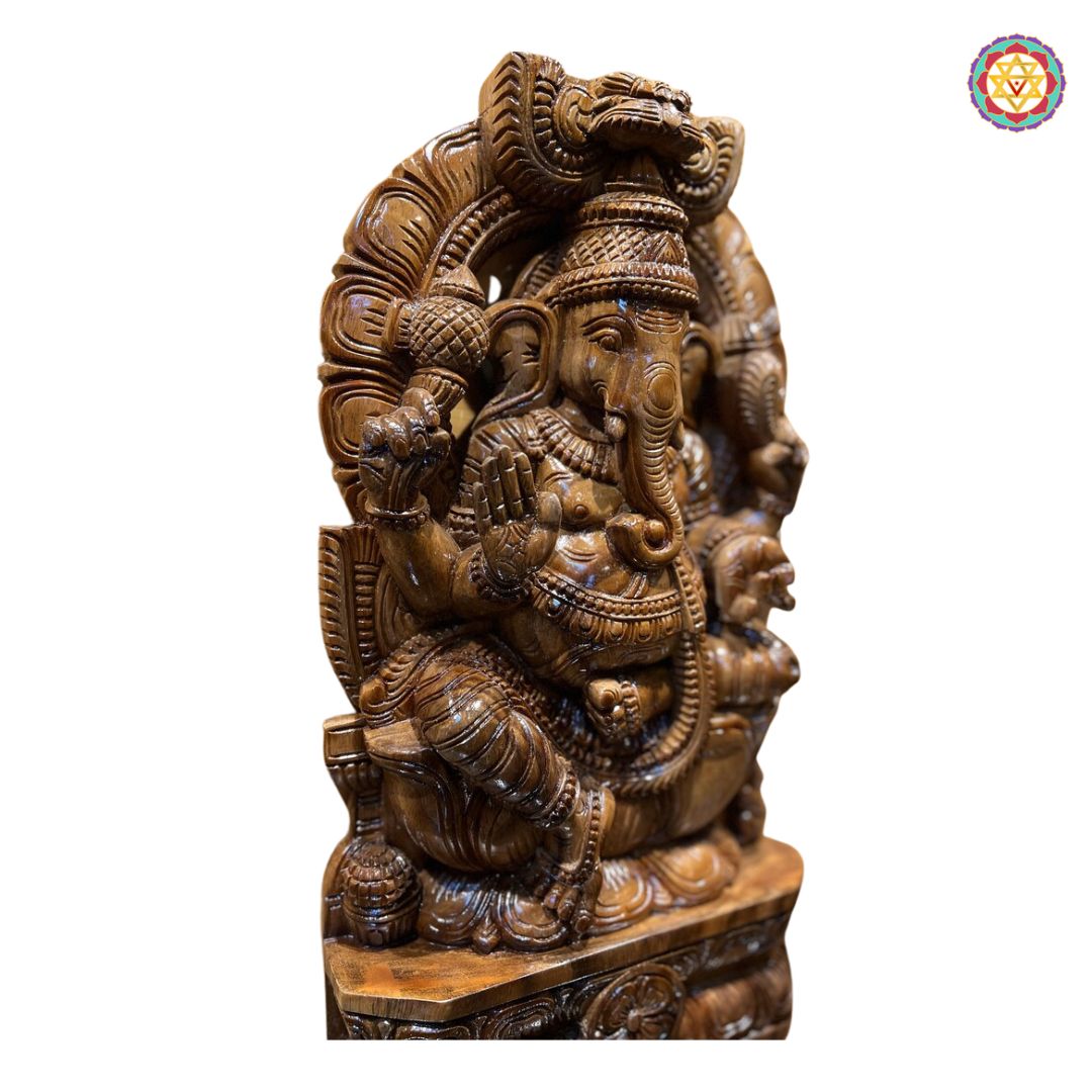 Close-up of Ganesha wooden sculpture — intricate carving of face, jewelry, and throne, handcrafted in antique gold brown finish