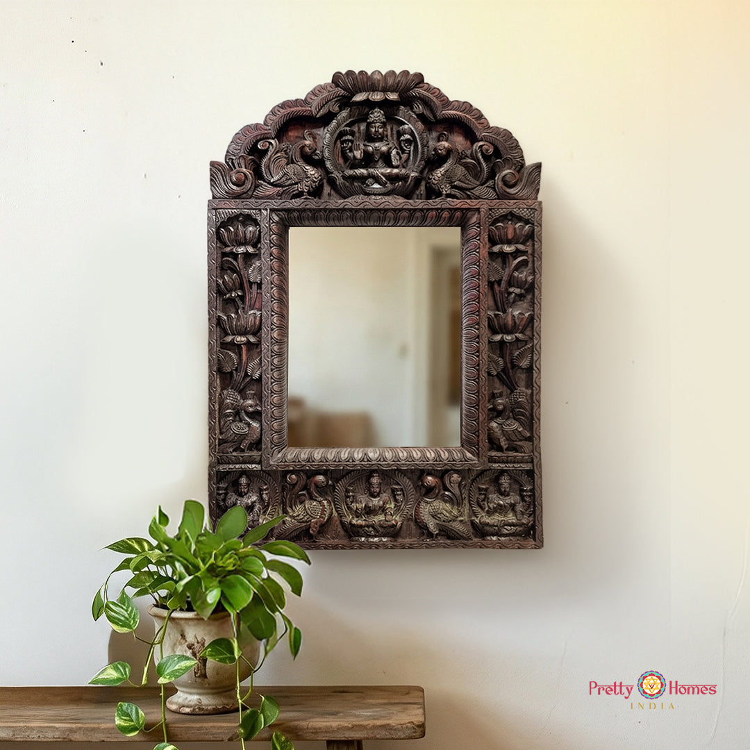 A vertical arched hand-carved mahogany mirror frame featuring Goddess Laxmi.