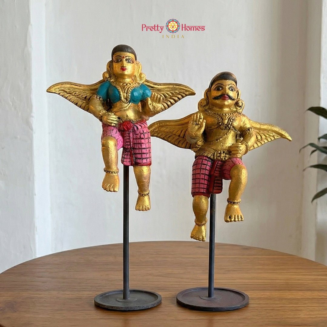 A pair of hand-carved teak wood Gandharvas in a serene blessing pose with a vibrant multicolour finish.