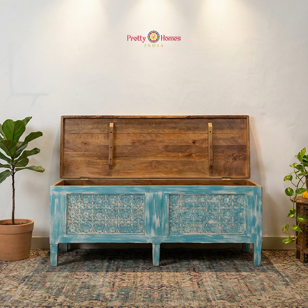 A horizontal hand-carved solid wood console storage trunk in a unique rustic blue finish.